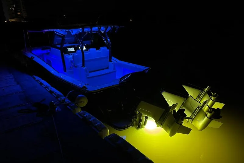  Yacht Photos Pics 2020 Scout 355 LXF boat illuminated at night with blue and yellow lights.