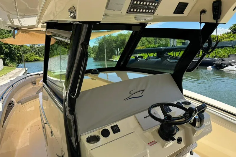 Yacht Photos Pics 2020 Scout 355 LXF boat helm with steering wheel, controls, and waterway view.