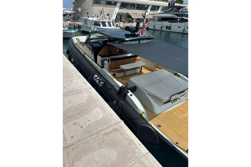 Rmf Yacht Photos Pics 2022 SACS Rebel 47 yacht docked at marina, featuring sleek design and spacious deck.