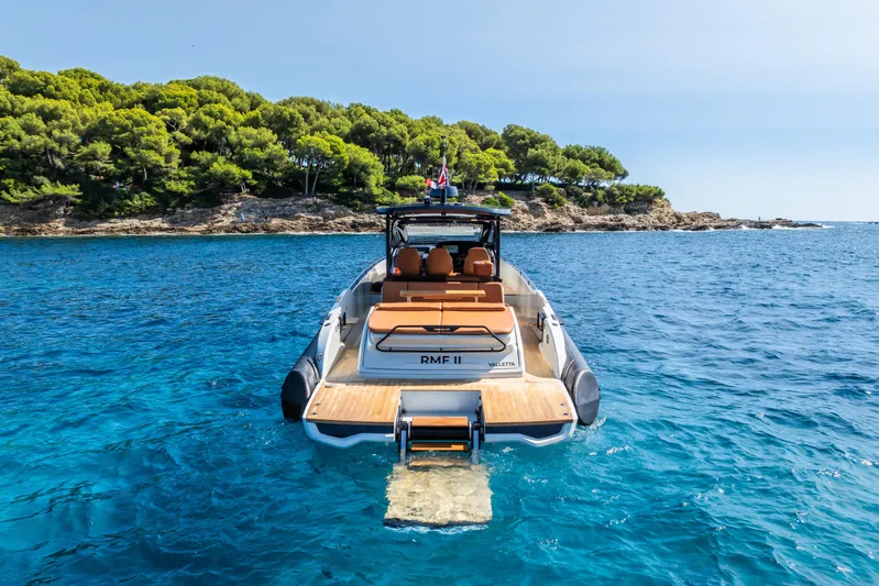 Rmf Yacht Photos Pics SACS Rebel 47 Yacht 2022 near wooded coastline in blue sea.