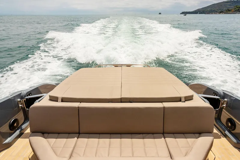 Rmf Yacht Photos Pics 2022 SACS Rebel 47 yacht cruising on open water, rear view with wake trail.