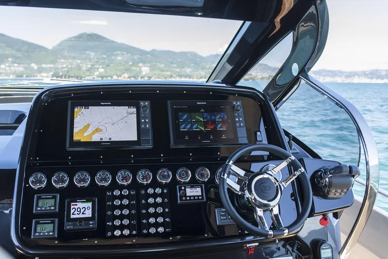 Rmf Yacht Photos Pics 2022 SACS Rebel 47 dashboard with navigation screens and controls, set against a scenic ocean backdrop.