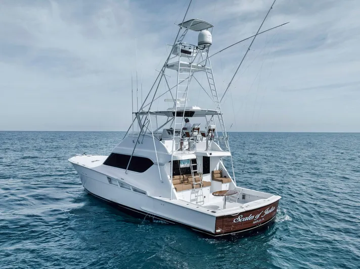 Scales Of Justice Yacht Photos Pics 1999 Hatteras 60 Convertible yacht on open sea, featuring a spacious deck and tower.