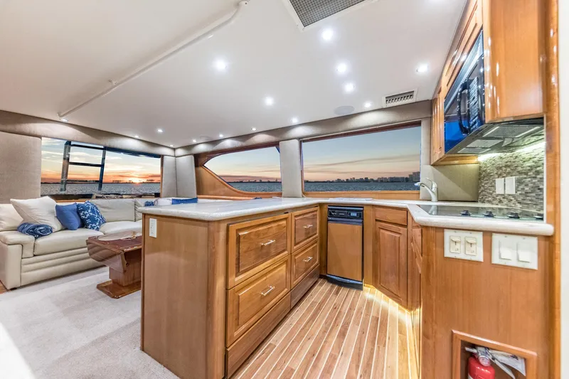 Scales Of Justice Yacht Photos Pics Luxurious interior of 1999 Hatteras 60 Convertible yacht with modern kitchen and sunset view.