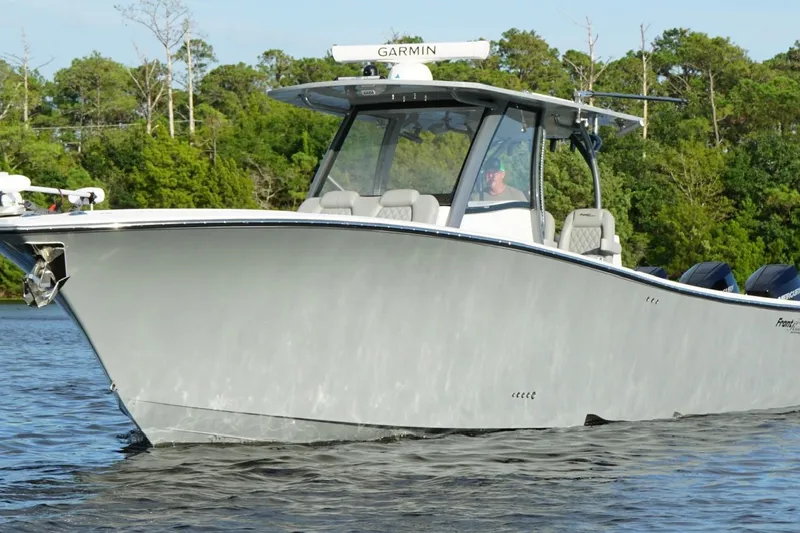  Yacht Photos Pics 2024 Front Runner 39 Center Console boat cruising on a calm lake with lush greenery.