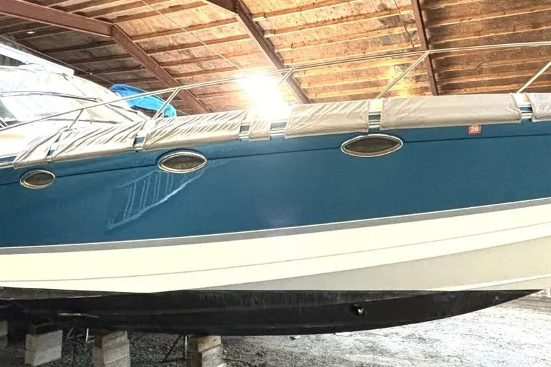  Yacht Photos Pics 2006 Formula 400 Super Sport Crossover boat in storage, blue hull, under wooden roof.