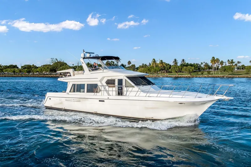 Motely Crew Yacht Photos Pics 2003 Navigator Rival 5700 yacht cruising on blue water under a clear sky.