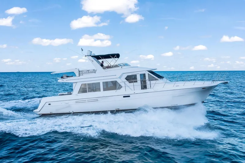 Motely Crew Yacht Photos Pics 2003 Navigator Rival 5700 yacht cruising on open blue sea under clear sky.