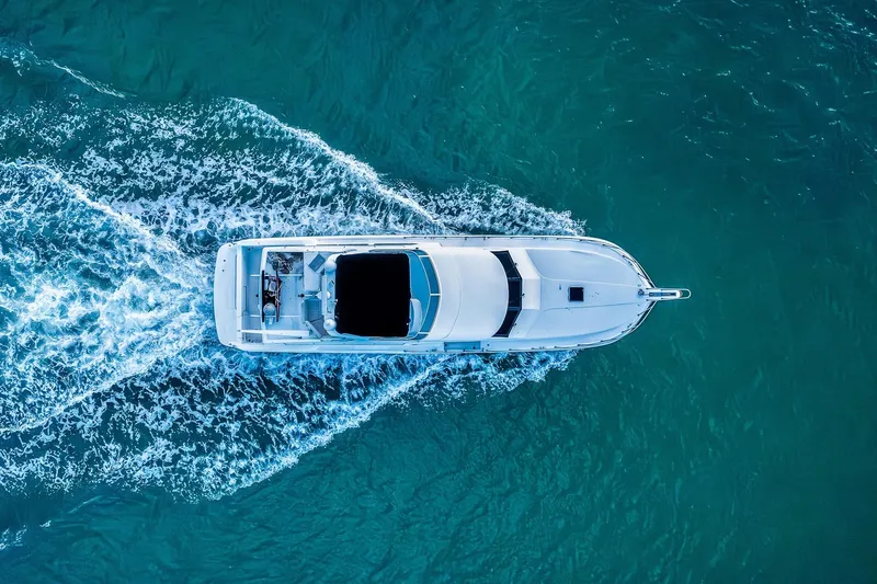 Motely Crew Yacht Photos Pics Aerial view of 2003 Navigator Rival 5700 yacht cruising in turquoise waters.