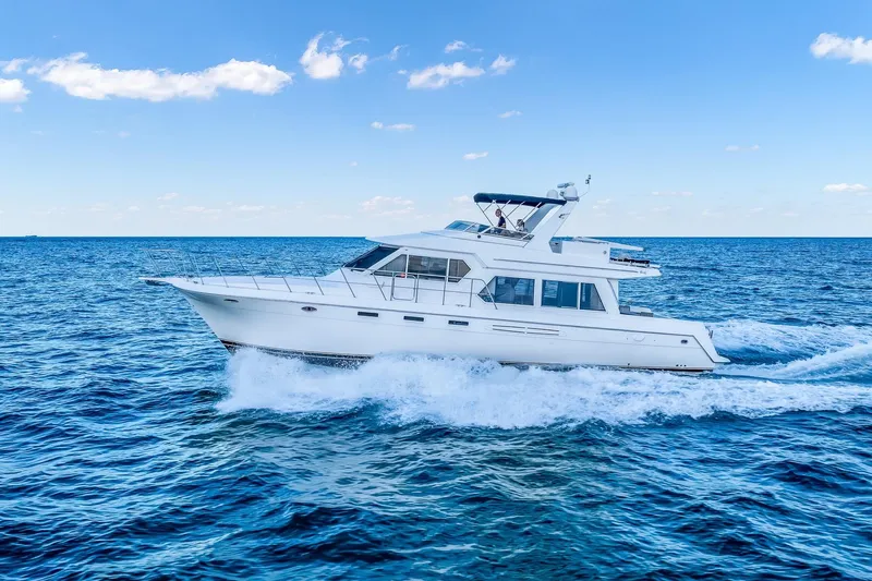 Motely Crew Yacht Photos Pics 2003 Navigator Rival 5700 yacht cruising on open blue sea under clear sky.