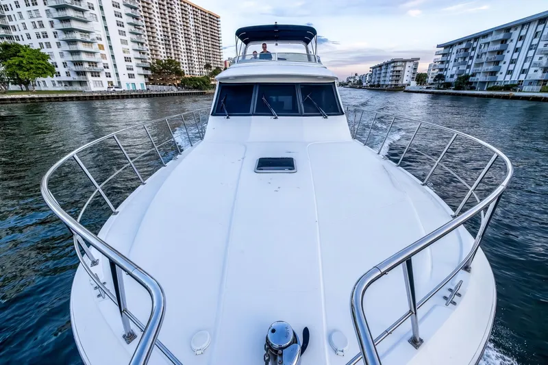 Motely Crew Yacht Photos Pics 2003 Navigator Rival 5700 yacht cruising through a city canal, surrounded by buildings.