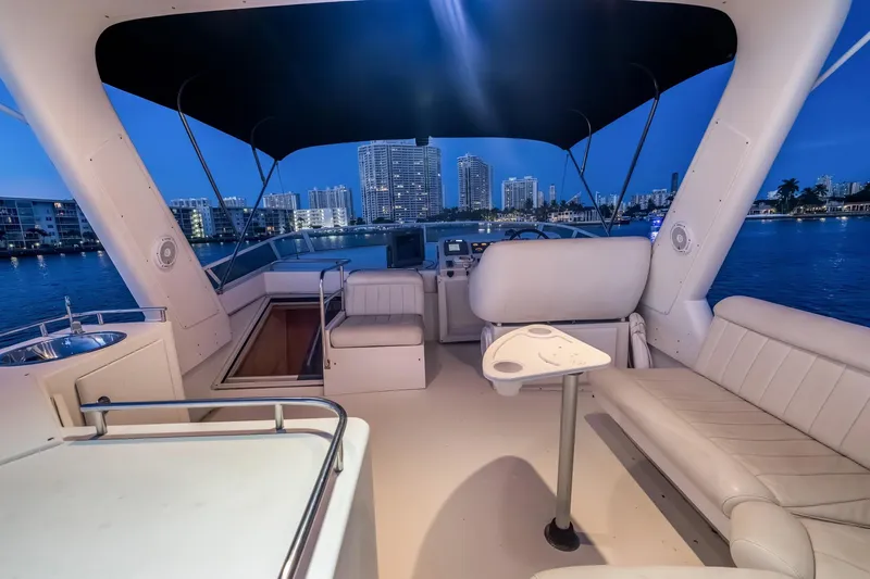 Motely Crew Yacht Photos Pics Luxurious 2003 Navigator Rival 5700 yacht interior with city skyline view at dusk.