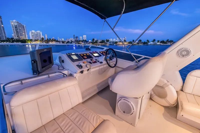 Motely Crew Yacht Photos Pics Luxurious 2003 Navigator Rival 5700 yacht interior with city skyline view at dusk.