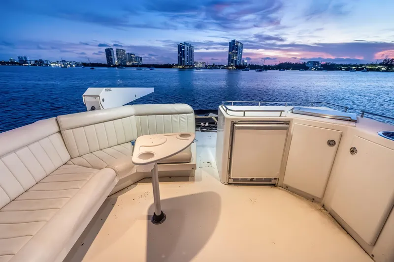 Motely Crew Yacht Photos Pics Luxurious 2003 Navigator Rival 5700 yacht deck with seating, overlooking serene waterfront cityscape.