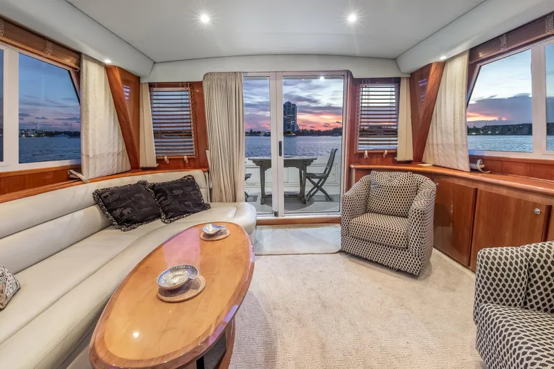 Motely Crew Yacht Photos Pics Luxurious 2003 Navigator Rival 5700 yacht interior with elegant seating and stunning sunset view.