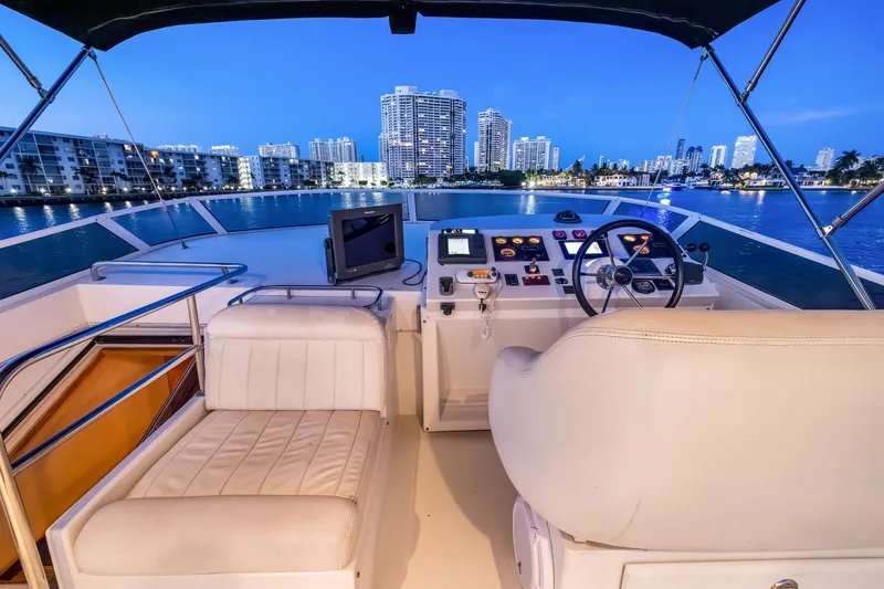 Motely Crew Yacht Photos Pics Luxurious 2003 Navigator Rival 5700 yacht interior with city skyline view at dusk.