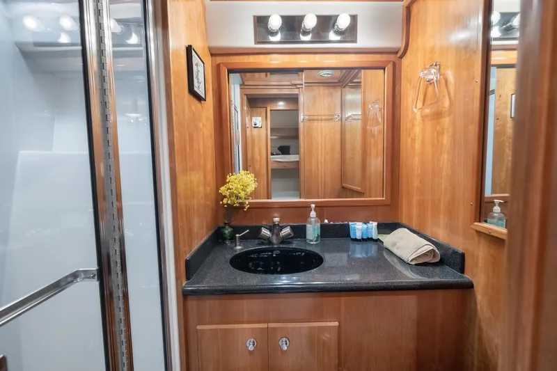 Motely Crew Yacht Photos Pics Luxurious wooden bathroom interior in 2003 Navigator Rival 5700 yacht, featuring elegant fixtures.