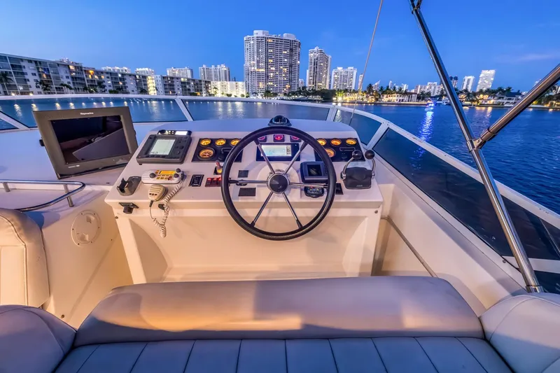 Motely Crew Yacht Photos Pics Cockpit of 2003 Navigator Rival 5700 yacht with city skyline at dusk.