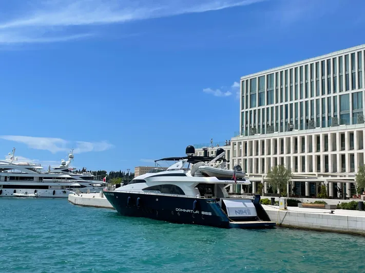 Nike Yacht Photos Pics Luxury yacht Dominator 860, 2007 model, docked near modern waterfront building.