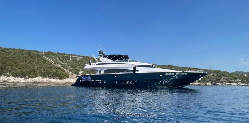 Nike Yacht Photos Pics Luxury 2007 Dominator 860 yacht cruising near a scenic coastline under clear blue skies.