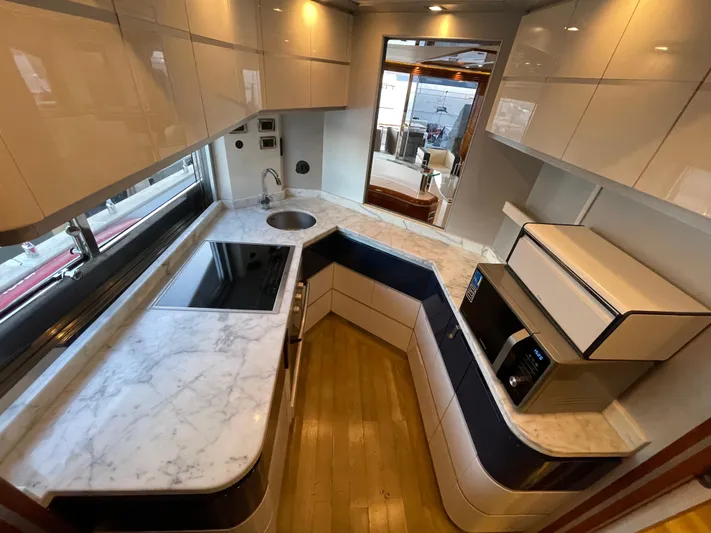Nike Yacht Photos Pics Luxurious yacht kitchen with marble countertops, modern appliances, and wooden flooring in a 2007 Dominator 860.