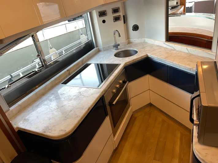 Nike Yacht Photos Pics Modern yacht kitchen with marble countertops, stainless steel appliances, and wooden flooring in a 2007 Dominator 860.