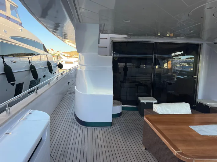 Nike Yacht Photos Pics Luxurious 2007 Dominator 860 yacht deck with wooden table and marina view.