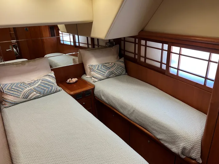 Off Line Yacht Photos Pics Twin beds in a 2007 Symbol PHMY yacht cabin with wooden accents and soft lighting.