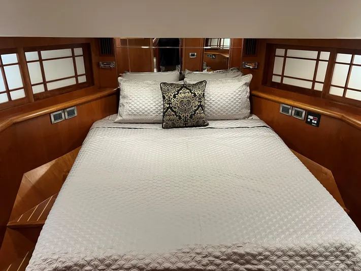 Off Line Yacht Photos Pics Luxurious yacht bedroom with elegant bedding, wood paneling, and decorative pillow, Symbol PHMY 2007.
