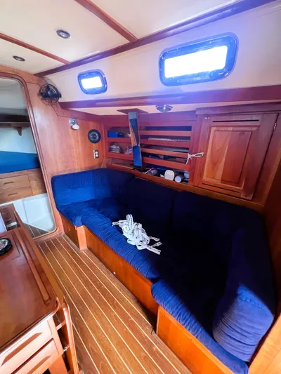  Yacht Photos Pics Interior of 2003 Tartan 4100 sailboat with blue seating and wooden finishes.