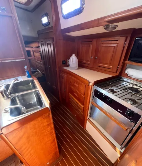  Yacht Photos Pics 2003 Tartan 4100 yacht interior with wooden cabinetry and kitchen amenities.