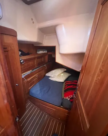  Yacht Photos Pics Cozy cabin interior of 2003 Tartan 4100 sailboat with wooden furnishings and bed.