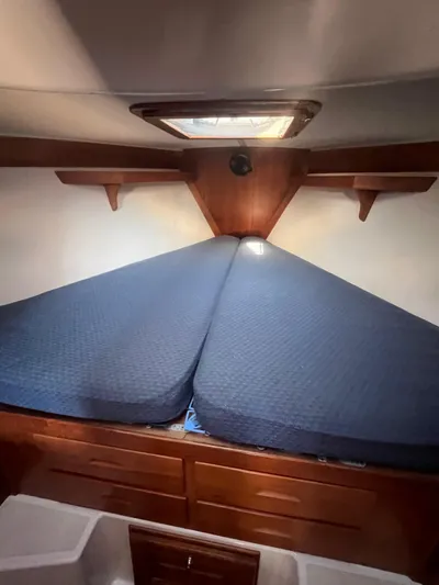  Yacht Photos Pics Cozy cabin interior of 2003 Tartan 4100 sailboat with blue bedding.