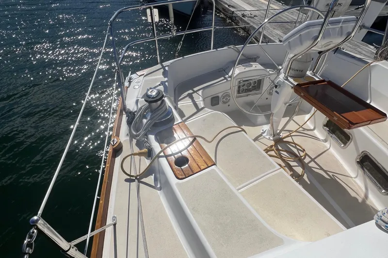 Yacht Photos Pics 2003 Tartan 4100 sailboat cockpit with wooden accents and steering wheel, docked by the water.