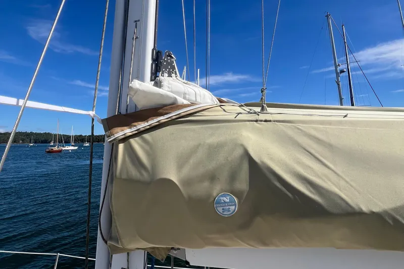  Yacht Photos Pics Sailboat Tartan 4100 (2003) with covered sail, anchored in a serene harbor.