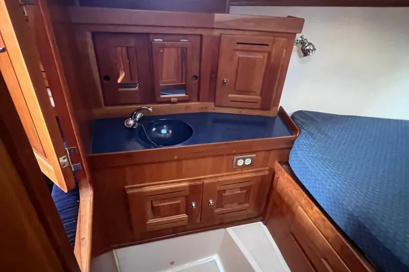  Yacht Photos Pics Wooden interior of 2003 Tartan 4100 yacht with sink and storage cabinets.
