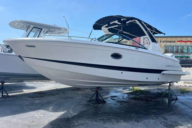  Yacht Photos Pics 2025 Chaparral 270 OSX boat on stands, white hull, black accents, outdoor storage.