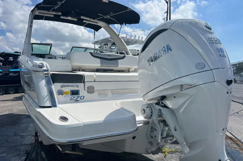  Yacht Photos Pics 2025 Chaparral 270 OSX boat with Yamaha engine, docked under a sunny sky.