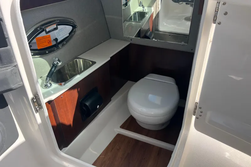  Yacht Photos Pics 2025 Chaparral 270 OSX boat bathroom with sink, toilet, and mirror.