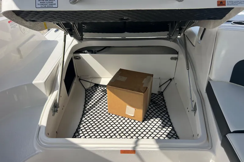  Yacht Photos Pics Open storage compartment in 2025 Chaparral 270 OSX boat with a cardboard box inside.