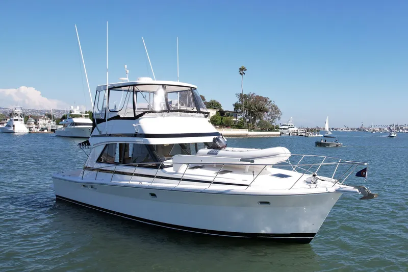 Seafood (reserved) Yacht Photos Pics 1998 Riviera 43 Open Flybridge yacht on calm water, clear sky, marina background.