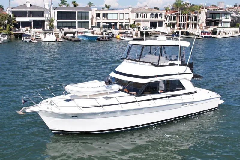 Seafood (reserved) Yacht Photos Pics 1998 Riviera 43 Open Flybridge yacht cruising near waterfront homes.