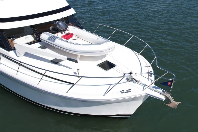 Seafood (reserved) Yacht Photos Pics 1998 Riviera 43 Open Flybridge yacht with inflatable boat on deck, anchored in calm waters.