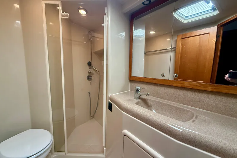 Seafood (reserved) Yacht Photos Pics Bathroom interior of 1998 Riviera 43 Open Flybridge yacht, featuring shower, sink, and mirror.