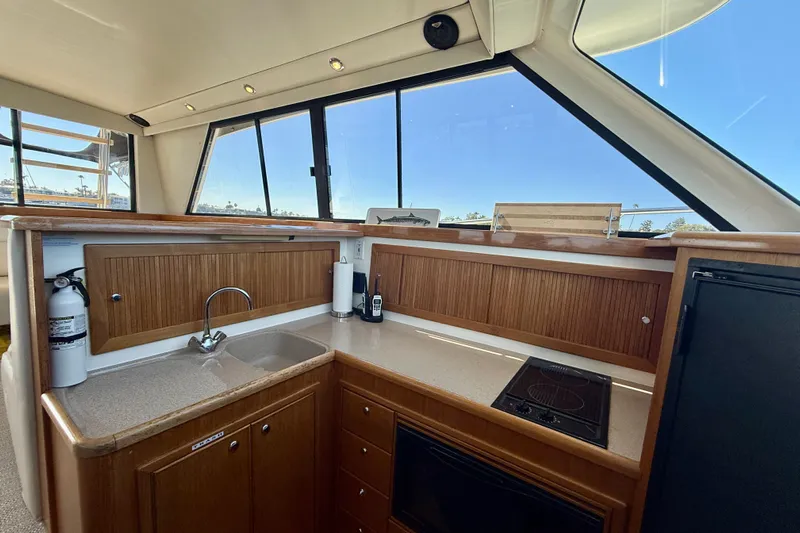 Seafood (reserved) Yacht Photos Pics Interior of 1998 Riviera 43 Open Flybridge yacht kitchen with wooden cabinets and appliances.