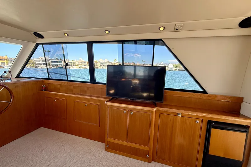 Seafood (reserved) Yacht Photos Pics Interior of 1998 Riviera 43 Open Flybridge yacht with TV and waterfront view.