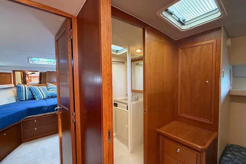 Seafood (reserved) Yacht Photos Pics Interior of 1998 Riviera 43 Open Flybridge yacht with wood paneling and cozy bedroom.
