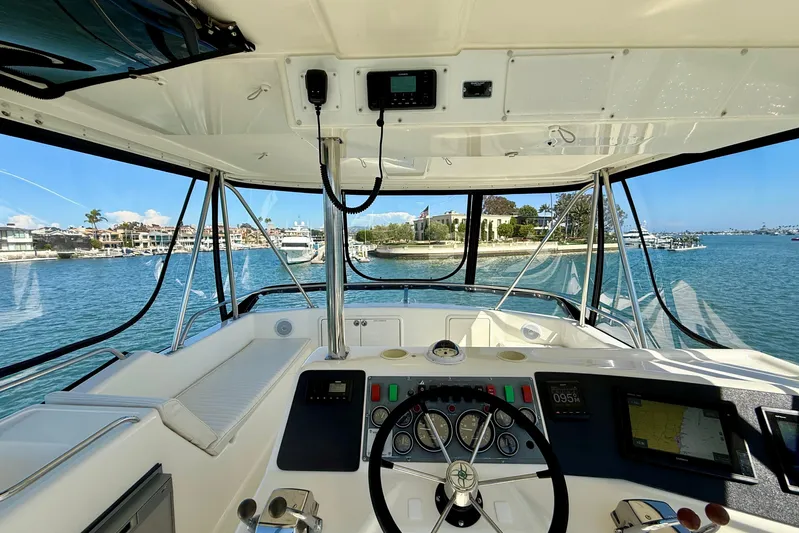 Seafood (reserved) Yacht Photos Pics Interior view of 1998 Riviera 43 Open Flybridge yacht, showcasing helm and waterfront scenery.