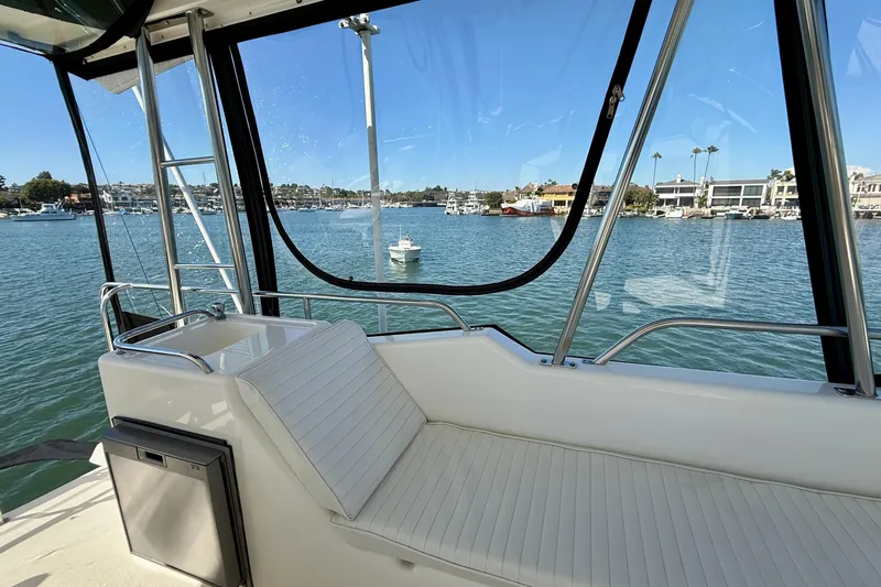 Seafood (reserved) Yacht Photos Pics 1998 Riviera 43 Open Flybridge interior with waterfront view, featuring sleek seating and modern design.