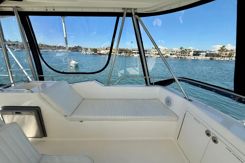 Seafood (reserved) Yacht Photos Pics 1998 Riviera 43 Open Flybridge interior with waterfront view, featuring comfortable seating and sleek design.